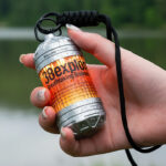 A flat lay photo showing a collection of modern, essential everyday carry (EDC) tools, including a minimalist wallet, a small flashlight, a rugged multi-tool knife, and a tactical pen, all laid out on a dark background.